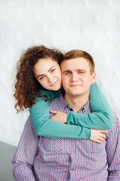 Um casal apaixonado olha para a lente da câmera contra o fundo — Fotografia de Stock