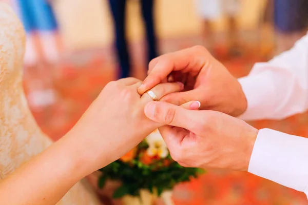 Close-up, o noivo coloca em um anel de casamento no dedo do seu — Fotografia de Stock