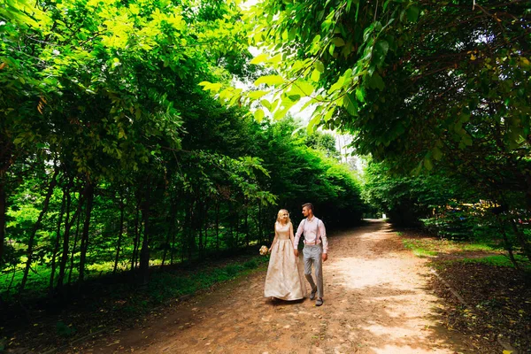 Vacker flicka i en lång klänning promenader med sin pojkvän och ho — Stockfoto