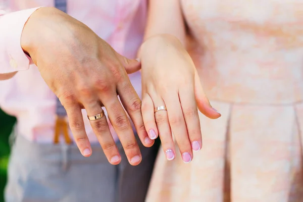 The bride and groom show their hands with wedding rings on the f Royalty Free Stock Photos