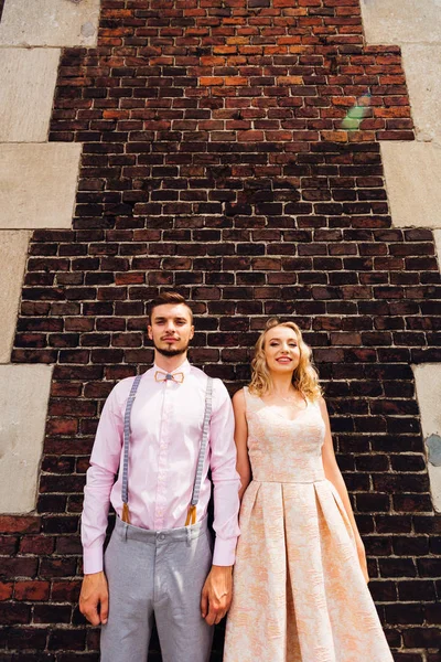 Le couple amoureux se tient sur le fond d'un mur de briques et — Photo