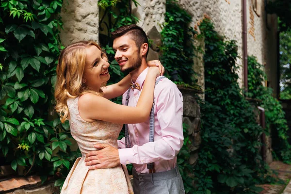 Meisje lachen en haar vriend in een roze shirt en hout knuffelen — Stockfoto