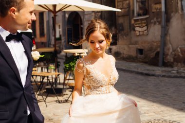Güzel gelin, damat görünüyor ve şehrin eski kesiminde yürüyerek