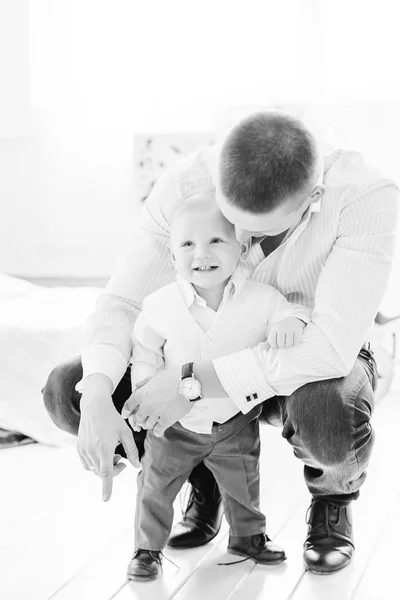 父は白黒写真で父の手を握っている小さな息子の近くに座り — ストック写真