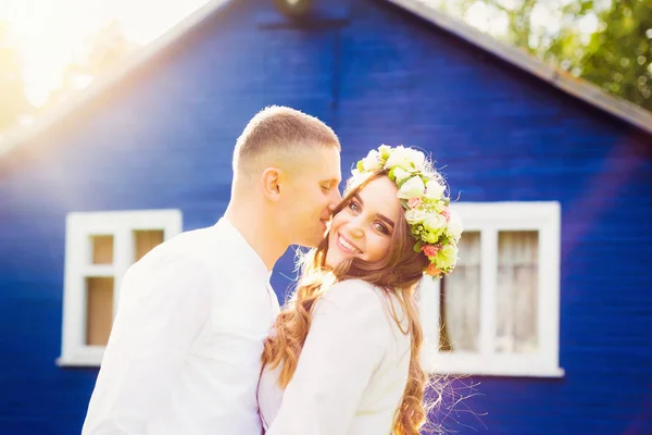 Man wil zijn mooie vrouw kussen tegen een blauwe huis — Stockfoto