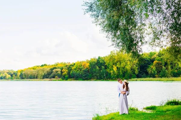 Feliz e sorrindo casal no fundo de um belo lago um — Fotografia de Stock