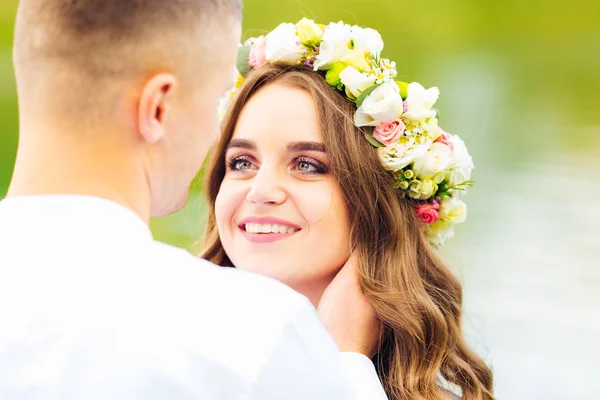 Schattig meisje met de krans op het hoofd kijkt naar haar vriendje en — Stockfoto