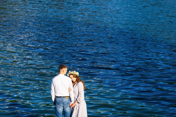 A beautiful girl with a wreath on her head hugged husband behind — Stock Photo, Image