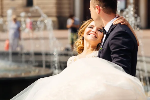 Der Bräutigam hält seine geliebte Braut im Arm — Stockfoto