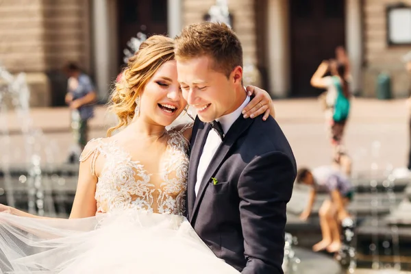 Bir fou arka plan üzerinde güzel yeni evliler samimi gülümsüyor — Stok fotoğraf
