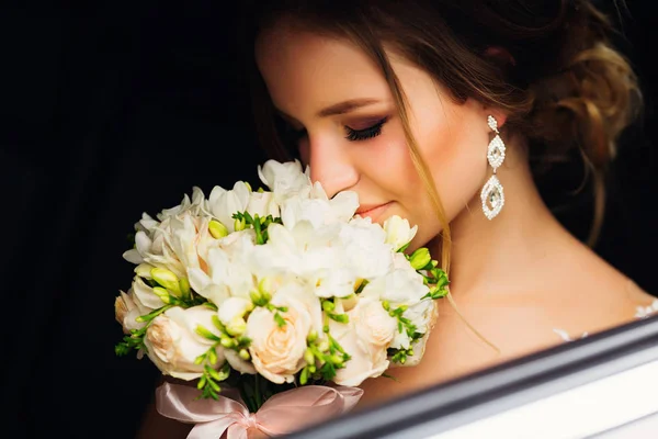 Rosto bonito de uma jovem sentada em um carro e flo cheiro — Fotografia de Stock