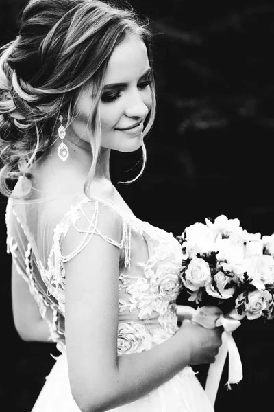 Primo piano di una splendida sposa sorridente che tiene un bouquet da sposa o — Foto Stock