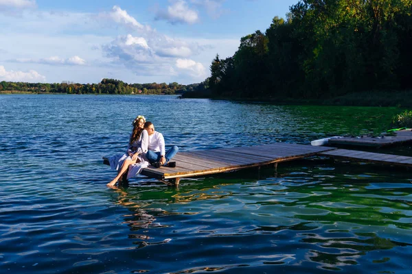 A mulher e seu marido estão sentados no cais do lago um — Fotografia de Stock