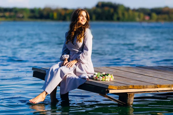 Das Mädchen Sitzt Auf Einem Hölzernen Steg Und Tränkt Ihre — Stockfoto