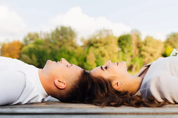 Muž a žena leží na povrchu dřevěná hlava na hlavě a s — Stock fotografie