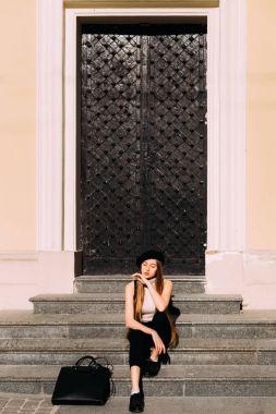 Evin bir anc ile merdiven üzerinde oturan güzel kız