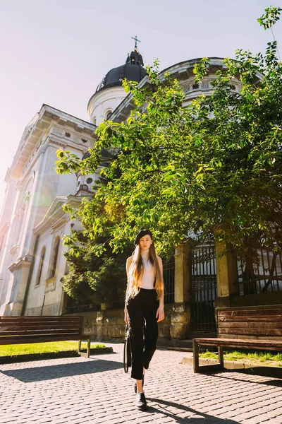 Девушка в берете на фоне старой церкви и дерева — стоковое фото