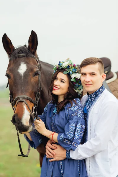 A lány úgy néz ki, a ló, és tartja a kantár és a bo — Stock Fotó