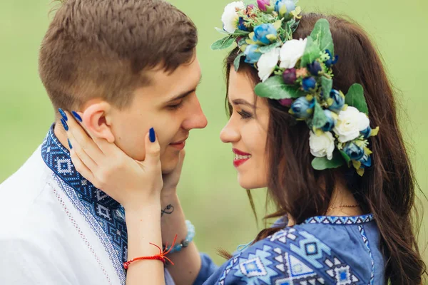 Het meisje kijkend naar haar vriendje en knuffelen hem door haar handen — Stockfoto