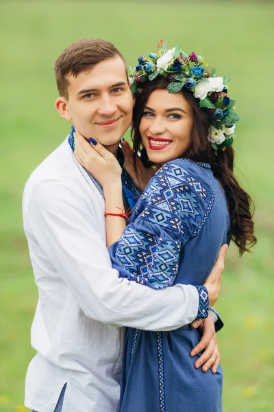 Un tipo con una chica en ropa bordada pasa el tiempo y abraza — Foto de Stock