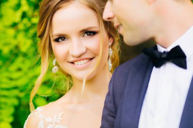 Güzel bir makyaj ve şık küpe damat yanında duran güzel bir gelinle Close-up