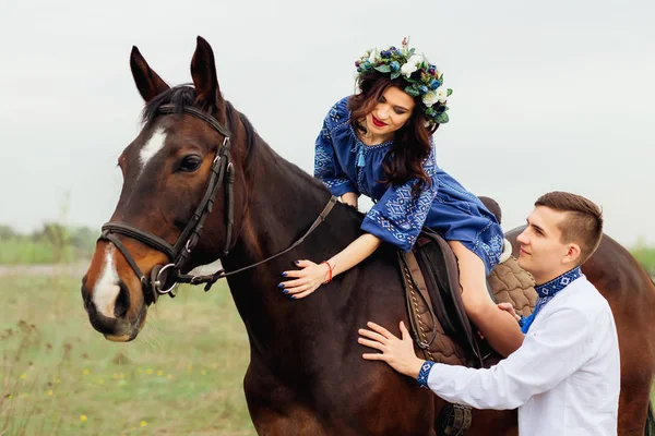 The girlfriend is sitting on a horse and her boyfriend is standi — Stock Photo, Image
