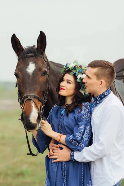 Пара праздничных нарядов, стоящая рядом с лошадью и смотрящая на — стоковое фото