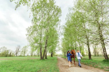 bir adam ve kız arkadaşı şenlikli giysili köyün yürüyüş ve bir at at başlığı arkasında tutmak