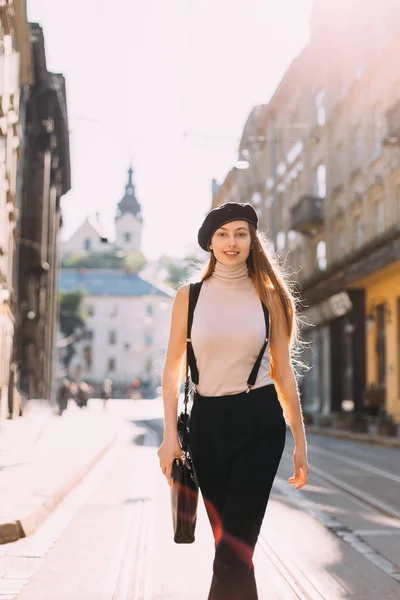 Een meisje met lang haar en stijlvolle kleding en een handtas op haar s — Stockfoto