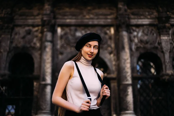 A girl with a smiling on her face and holds the suspenders in th — Stock Photo, Image