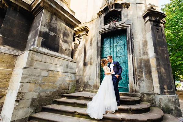 Elegantes recién casados quieren besarse sobre un fondo de hermoso bullicio — Foto de Stock