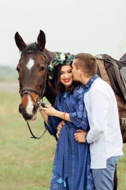 adam usulca kafasına bir çelenk ile güzel bir kız öpücük a at başlığı için bir at tutan