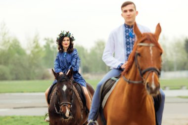 Kız ve erkek arkadaşı olan at binme ve kamera lensi seyir