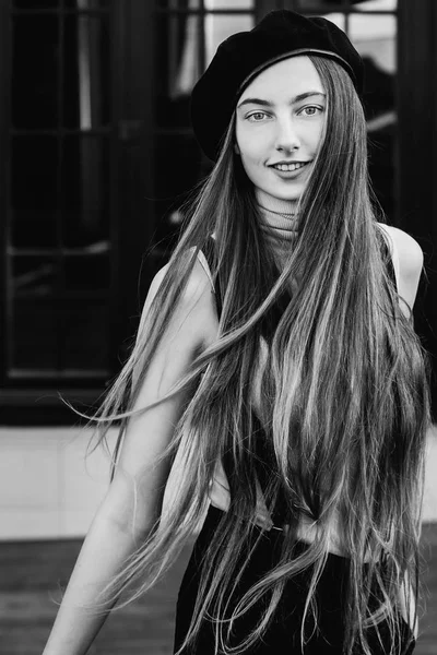 Крупним планом дівчина з красивим довгим волоссям посміхається на чорному і білому — стокове фото