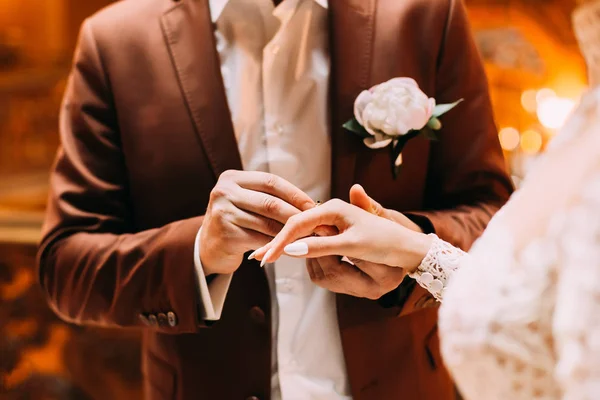 Bruidegom in stijlvolle bruine pak dragen van een trouwring op de vinger — Stockfoto