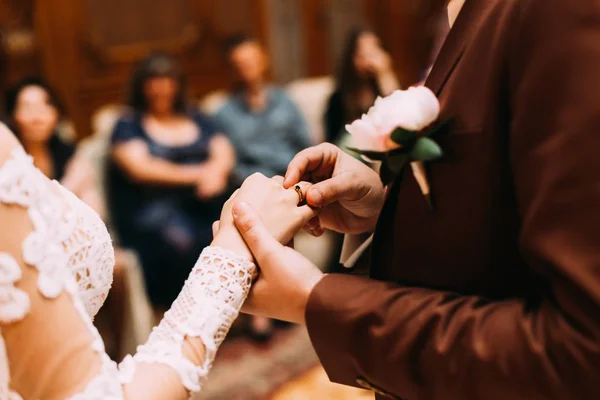 Жених в костюме с обручальным кольцом на пальце невесты — стоковое фото