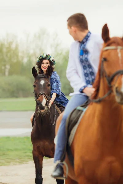 女孩微笑着她的男朋友骑在他面前的马 — 图库照片