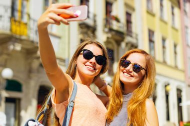 mutlu kız bir selfie şehrin arka plan üzerinde güneşli bir günde yapmak