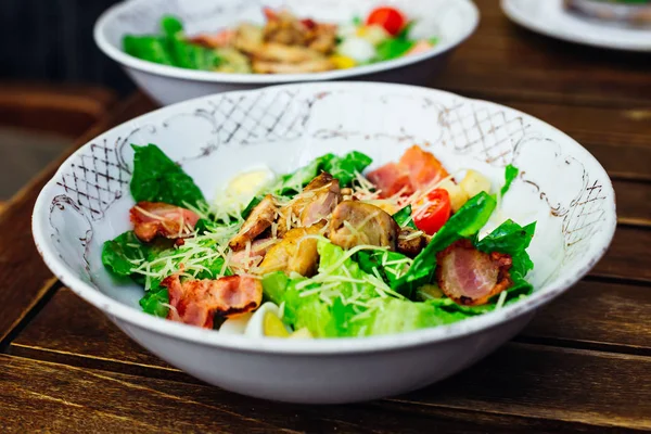 Deliziosa insalata fresca con verdure e pancetta su un tavolo di legno — Foto Stock