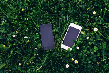 Close-up iki telefon yeşil çim üzerinde yalan