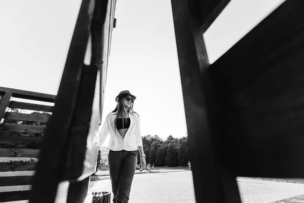 Девушка в модном образе прогулка по площади рядом с деревянным — стоковое фото