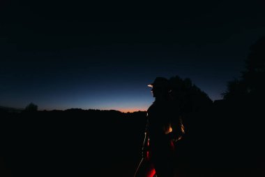 Bir kız için ışık parlıyor, onu arkasında hangi yatan doğa akşam zemin karşı bir silüeti Close-up