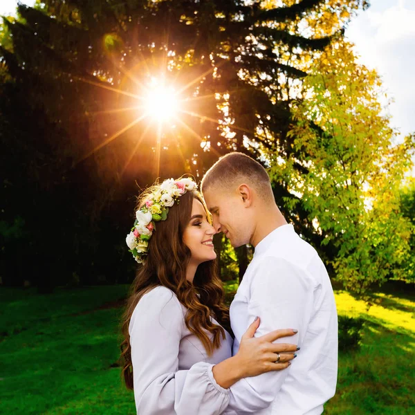 Man Hugs Haar Mooie Vrouw Met Een Krans Van Bloemen — Stockfoto