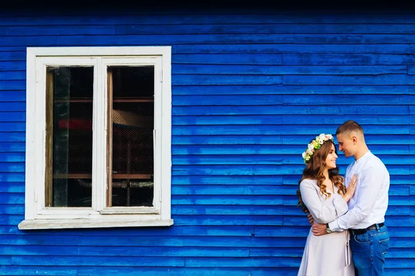 亲密的一对幸福的夫妇谁微笑附近的蓝色房子与一个白色的窗口 — 图库照片
