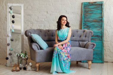 Güzel bir saç modeli ve nazik bir elbise ile bir kadın oturuyor