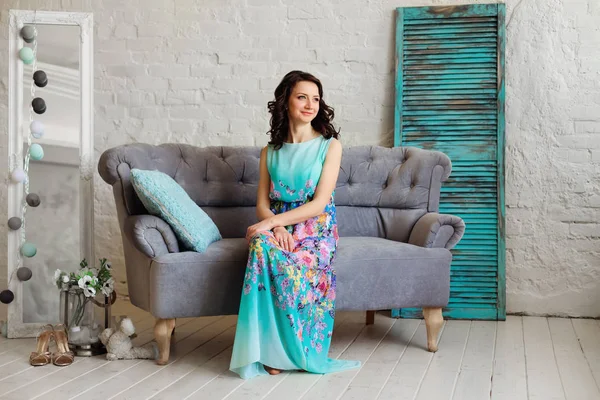 çok güzel bir elbise gri bir kanepede oturan zarif bir bayan