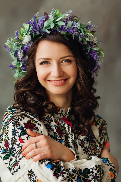 A woman in a chic embroidered dress and a wreath of lavender on — Stock Photo, Image