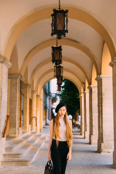 Tajemná dívka s dlouhými vlasy stojí pod oblouků s — Stock fotografie