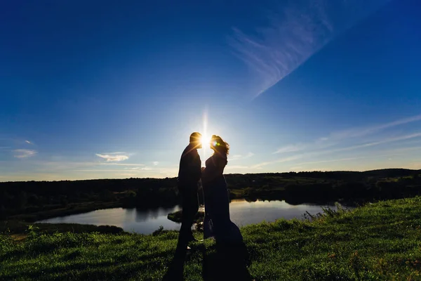 Homme heureux et femme enceinte sur le fond d'un lac sur une bri — Photo