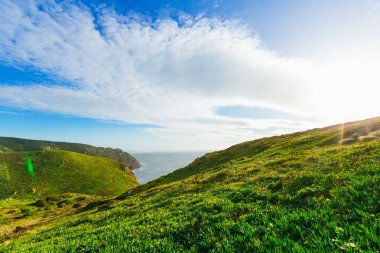 Sakin deniz ve yeşil tepeler üzerine iyi güneşli hava